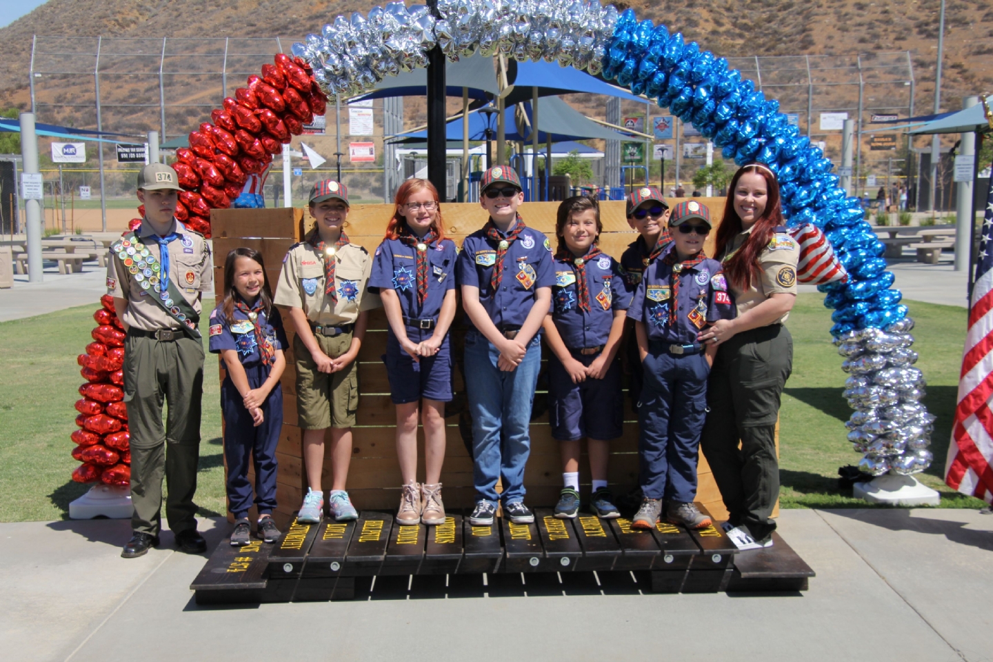 The crossover bridge that the graduating AOLs Scouts can walk across from the left side to the right side is situated up front. The Cubmaster and Assistant Cubmaster stand on the left side of the bridge. The troop representatives are called up and stand on the right side of the bridge.
